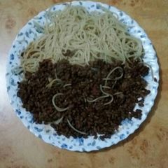 A picture of Spaghetti with brown green grams.