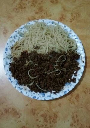A picture of Spaghetti with brown green grams.