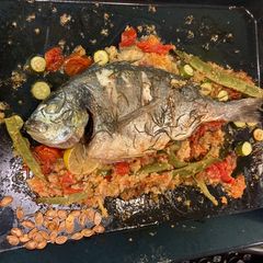 A picture of Roasted whole sea bream with all the trimmings on one roasting tin.