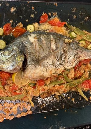 A picture of Roasted whole sea bream with all the trimmings on one roasting tin.