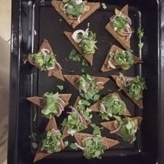 A picture of Vegan poached pear rocket and red onion 'pizza'.