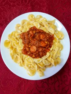 Una foto de Fideos Moños con Salsa Roja y Salchichas