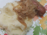 Puré de papas con longaniza en salsa de cebolla