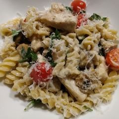 A picture of Chicken and mushroom pasta in parmesan sauce.
