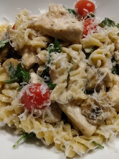 A picture of Chicken and mushroom pasta in parmesan sauce.