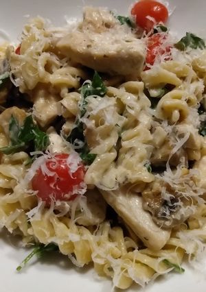 A picture of Chicken and mushroom pasta in parmesan sauce.