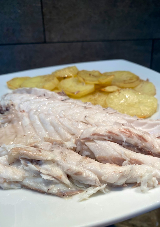 Una foto de Lubina al horno con patatas