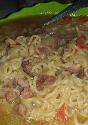 A picture of Noodles and beef soup.