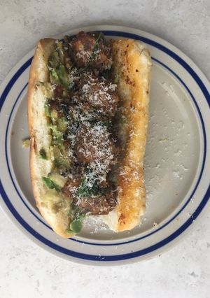 A picture of Leftover meatball sub with avocado.