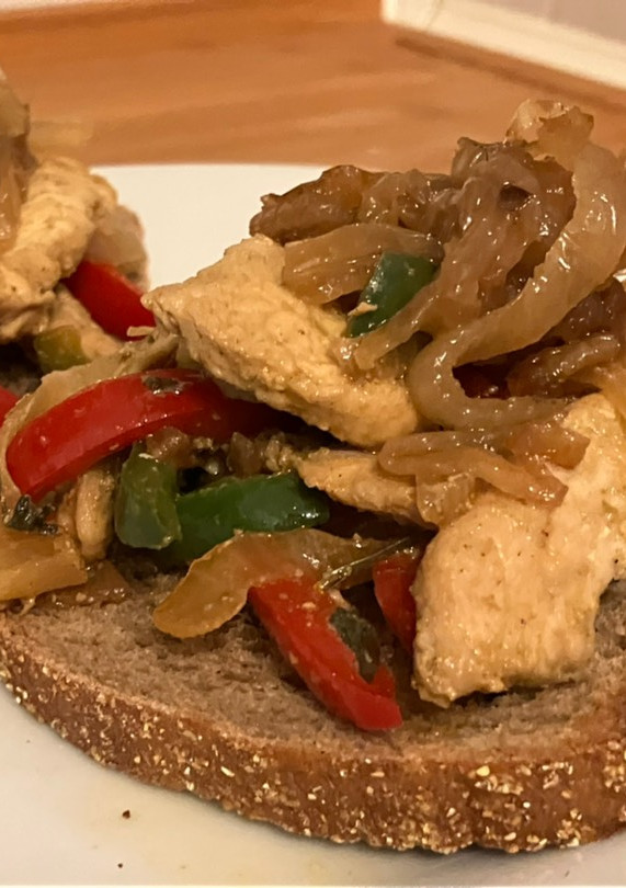 Una foto de Tostas con pollo, cebolla y pimientos