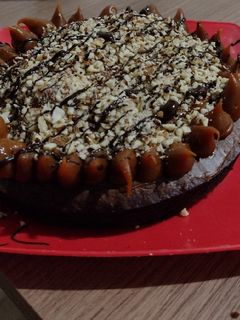 Una foto de Torta brownie decorada con dulce de leche y almendras