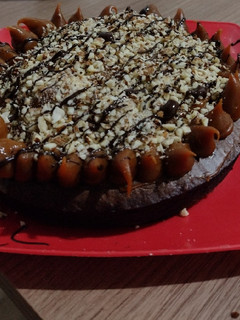 Una foto de Torta brownie decorada con dulce de leche y almendras
