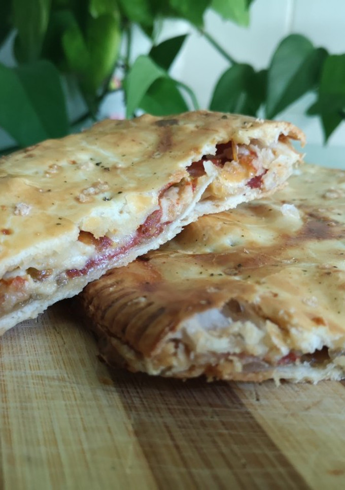 Una foto de Empanada de jamón ibérico y rulo de cabra con tomate y cebolla