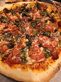 Una foto de Pizza de tomate, albahaca y jamón serrano