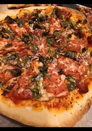 Una foto de Pizza de tomate, albahaca y jamón serrano