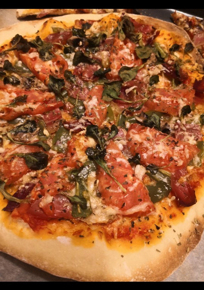 Una foto de Pizza de tomate, albahaca y jamón serrano