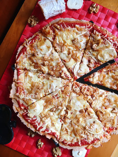 Una foto de Pizza de queso de cabra, cebolla caramelizada y nueces con base casera integral