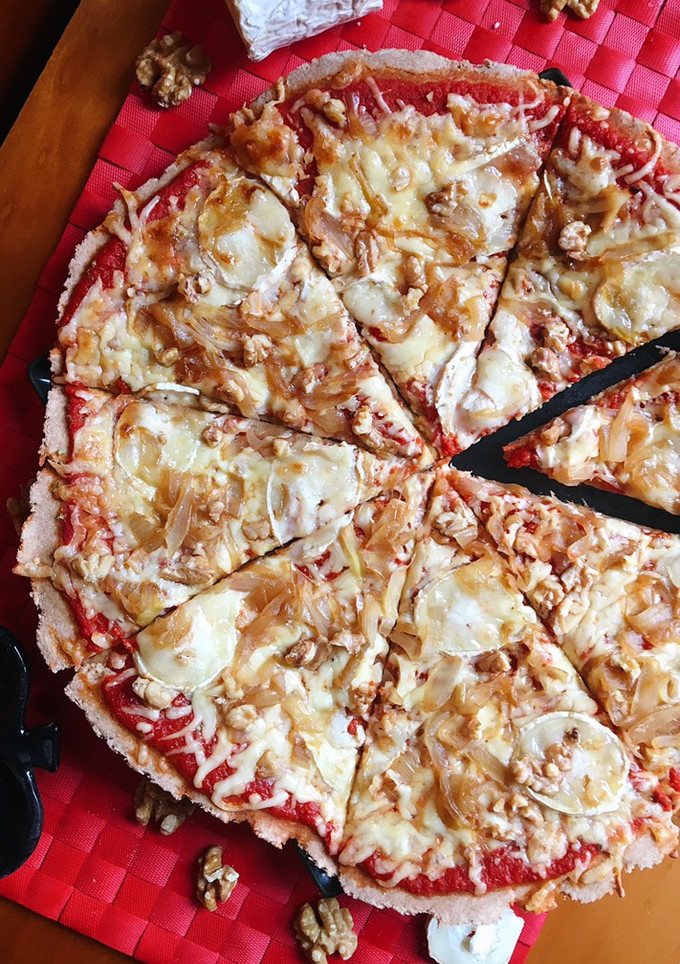 Una foto de Pizza de queso de cabra, cebolla caramelizada y nueces con base casera integral