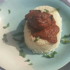A picture of White rice served with tomatoes stew.