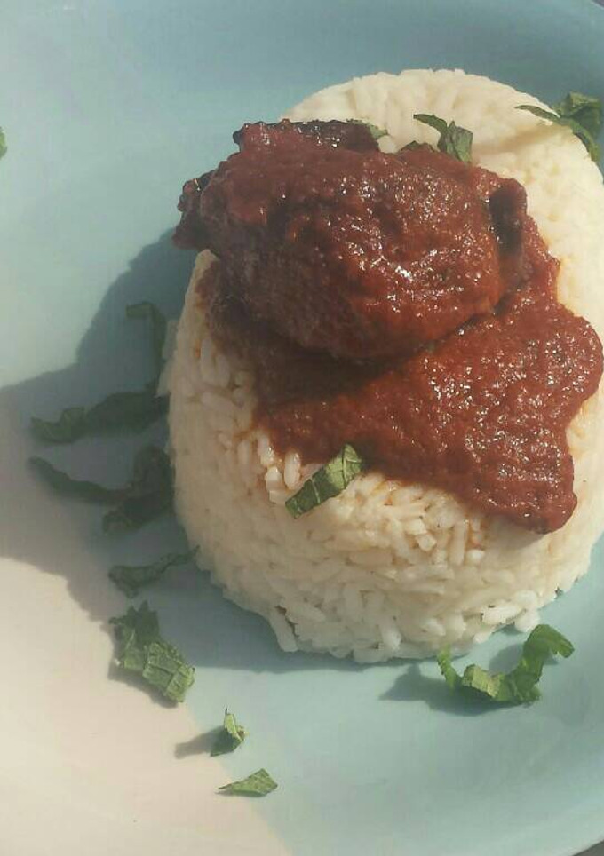 A picture of White rice served with tomatoes stew.