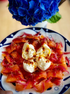 Una foto de Salmón marinado con burrata y aceite de tomate confitado