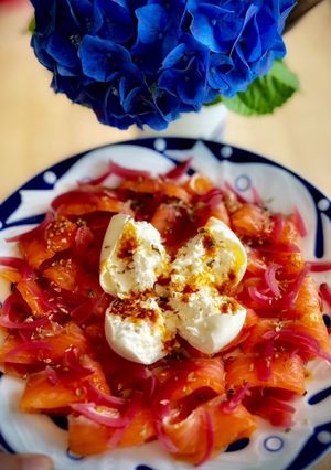 Una foto de Salmón marinado con burrata y aceite de tomate confitado
