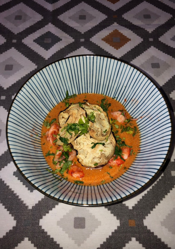 Una foto de Curry rojo con gambón y chipirones + chips de berenjena