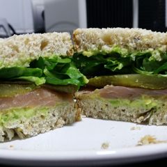 A picture of Avocado, smoked salmon and pickle sandwich.