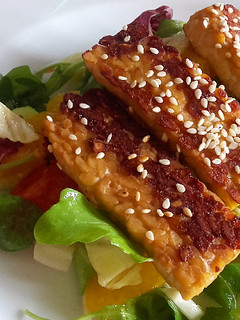 Una foto de Tempeh a la plancha con ensalada mixta y naranjas