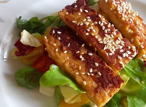 Una foto de Tempeh a la plancha con ensalada mixta y naranjas