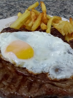 Una foto de Bifes de costilla a caballo con papas fritas
