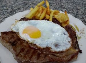 Una foto de Bifes de costilla a caballo con papas fritas