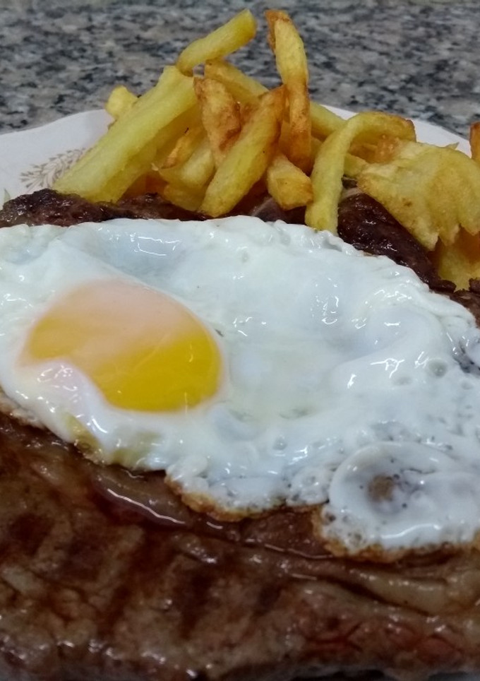 Una foto de Bifes de costilla a caballo con papas fritas