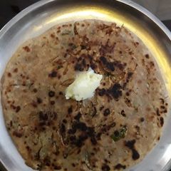 A picture of Mooli prantha with butter.