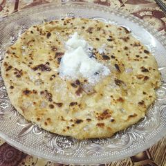 A picture of Onion paratha with butter.