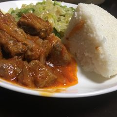 A picture of Ugali served with cabbage and beef wet fry.