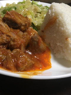 A picture of Ugali served with cabbage and beef wet fry.