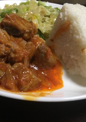 A picture of Ugali served with cabbage and beef wet fry.