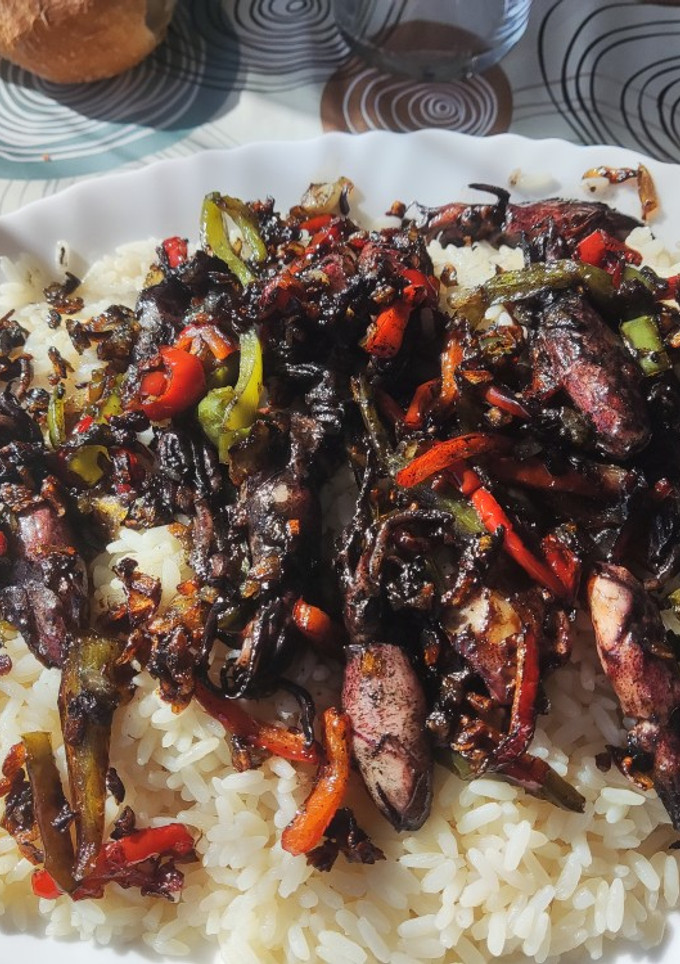Una foto de Chipirones en su tinta con arroz