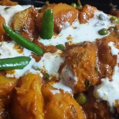 A picture of Kashmiri Dum Aloo with green peas.