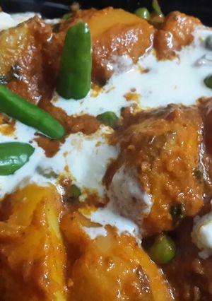 A picture of Kashmiri Dum Aloo with green peas.