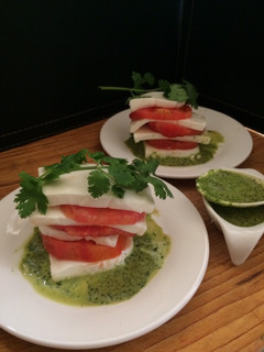 Una foto de Mil hojas de tomates con quesillo y salsa de cilantro