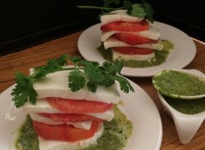 Una foto de Mil hojas de tomates con quesillo y salsa de cilantro