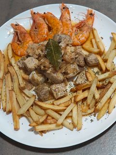 Una foto de Bonito encebollado con langostinos y patatas