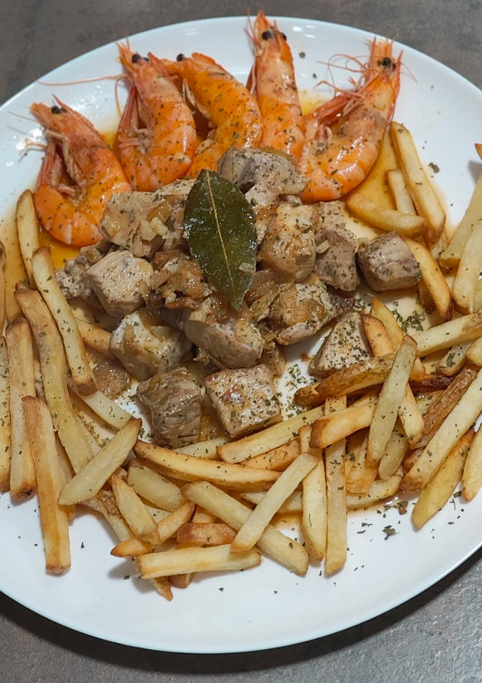 Una foto de Bonito encebollado con langostinos y patatas