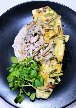 A picture of Asparagus omelette with a mushroom cream sauce.