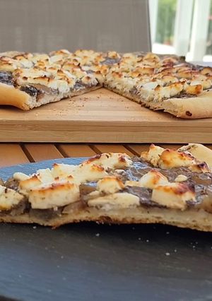 Una foto de Pizza casera de cebolla caramelizada y queso de rulo