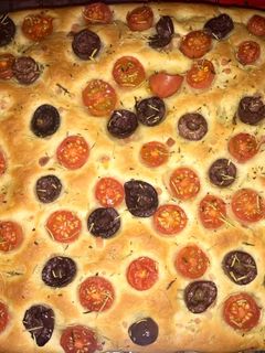 Una foto de Focaccia con tomate cherrys, aceitunas negras y romero seco