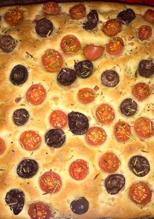 Una foto de Focaccia con tomate cherrys, aceitunas negras y romero seco