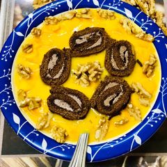 A picture of Swiss roll mangoes custard loaded with walnuts.
